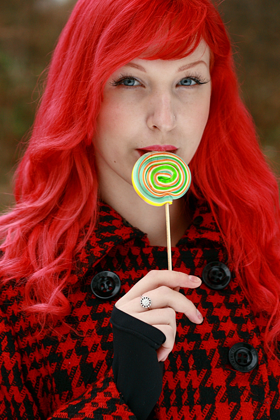 női portré piros hajjal és nyalókával