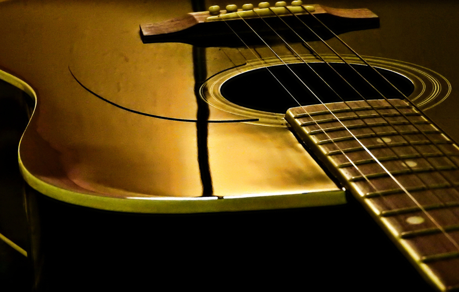 Fekete gitár a szoba fényében arannyá vált