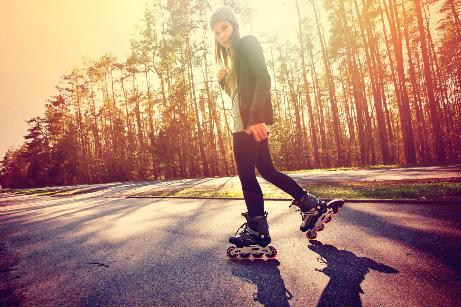Teenage girl on roller skates at summer.