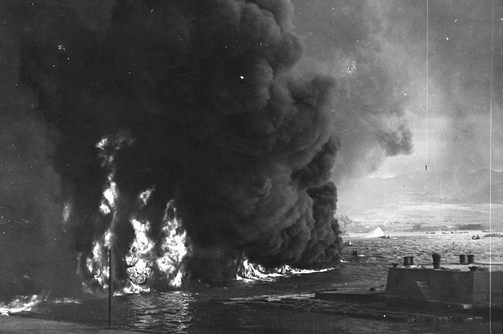 Oil burns on the waters of Pearl Harbor, near the naval air stat