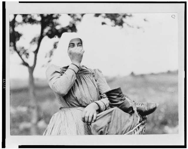 Woman carrying basket and shoes on way to market, Hungary 1923