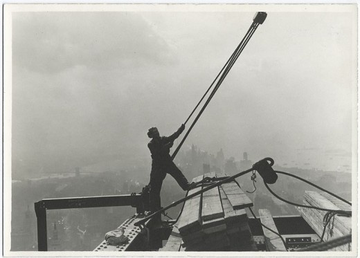 Construction-worker-maneuvering-rope-and-pulley-1931-520x373