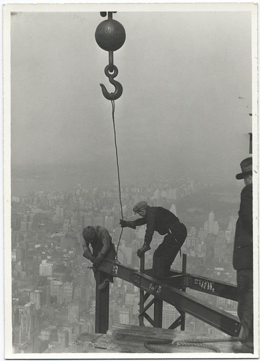 Two-workers-attaching-a-beam-with-a-crane-1931-520x722