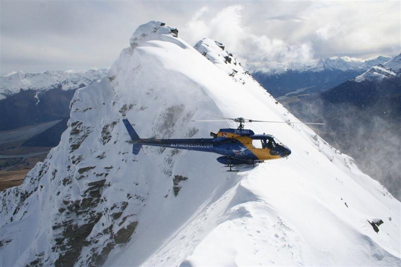 an alpine heliski ltd chopper sits atop temple pea