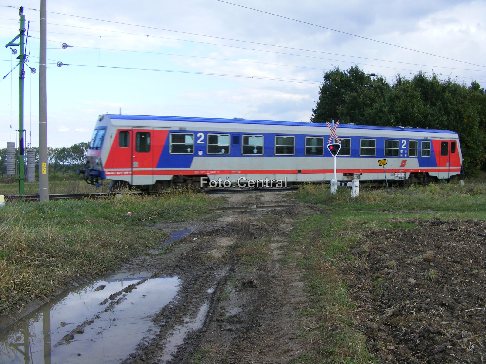 Az ÖBB egyik motorkocsija halad az SR 1-es vasúti átjárónál.